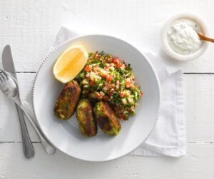 A vibrant vegetarian dish with spiced veggie koftas, fluffy couscous, roasted vegetables, and a tangy-sweet chilli yogurt dip for a balanced, flavorful bite.